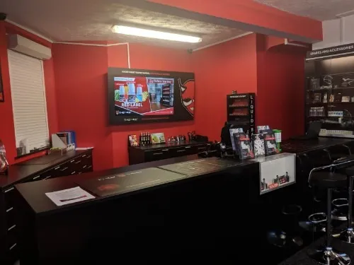Inside the Chorley shop: red walls, a long black counter with stools and a wall of spares and accessories
