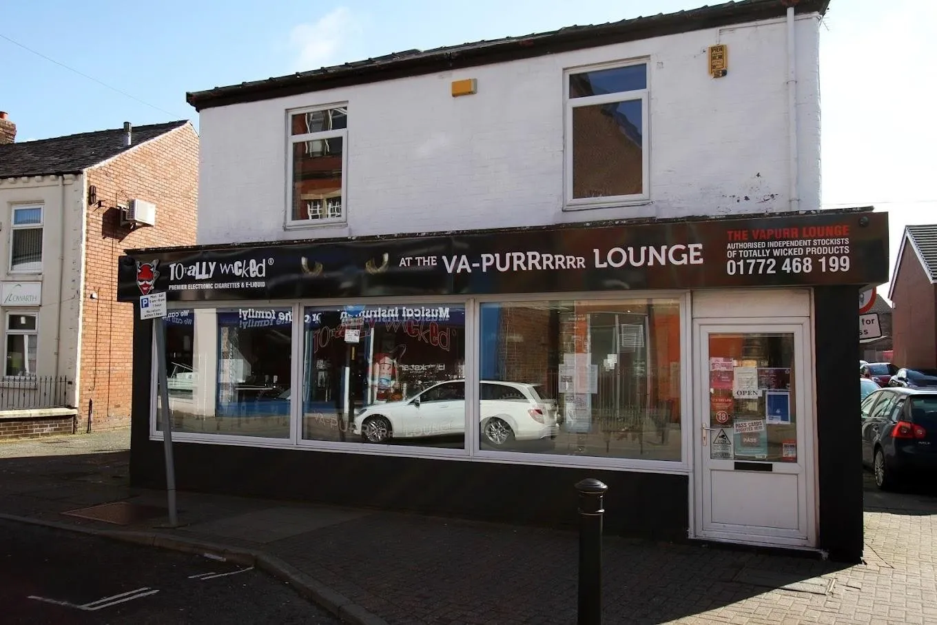The Leyland shop on Chapel Brow: a white building with a black sign reading "Totally Wicked at the Va-Purrrrr Lounge" and two amber cat eyes